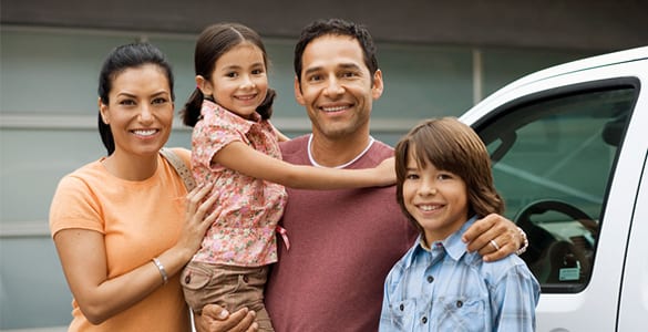 Family Standing Outside House Next To Car